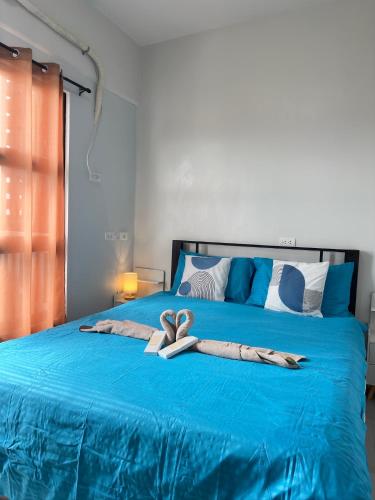 a blue bed with two heart towels on it at Azure Edge in Dauis