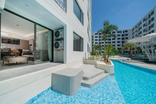 a house with a swimming pool with a bench next to a building at Capri Residence Bangtao in Bang Tao Beach