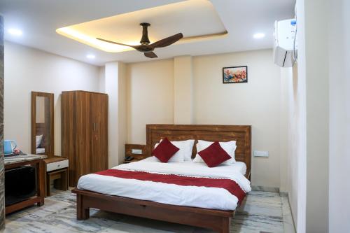 a bedroom with a bed with a ceiling fan at Hotel Omkara View Palace in Godarpura