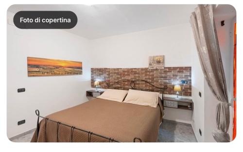 a bedroom with a bed and a brick wall at Camera dell' antico Arco Romano in Pozzuoli