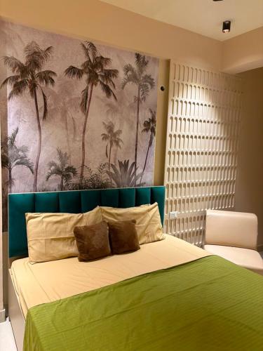 a bedroom with a green bed with a palm tree mural at Bright & Modern 1BHK in Ghaziabad