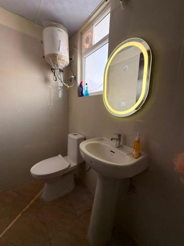 a bathroom with a sink and a toilet and a mirror at Bright & Modern 1BHK in Ghaziabad