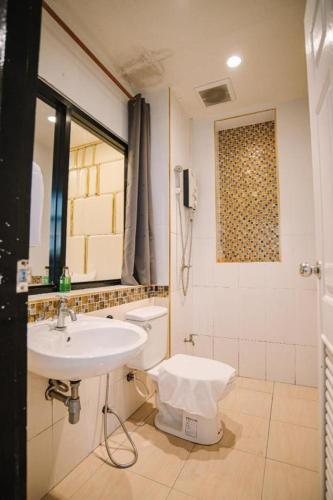 a bathroom with a sink and a toilet at Debua Mahasarakham in Maha Sarakham