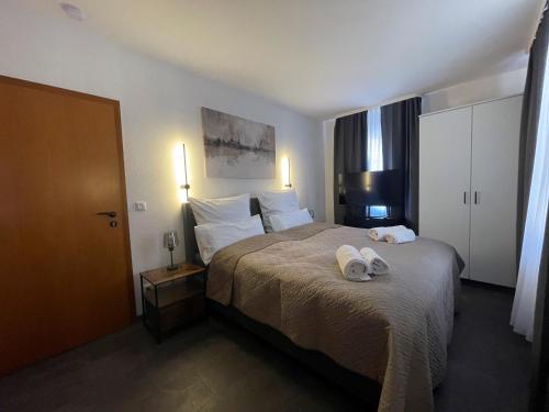 ein Hotelzimmer mit einem Bett, auf dem Handtücher liegen in der Unterkunft Steingarten Hotel in Wertheim