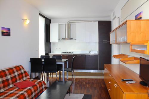 a kitchen and living room with a couch and a table at Residenza Nervesa in Lignano Sabbiadoro