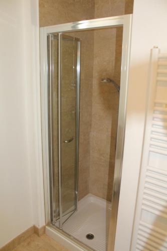 a shower with a glass door in a bathroom at Residenza Nervesa in Lignano Sabbiadoro