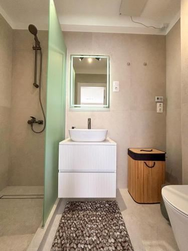 a bathroom with a sink and a tub and a mirror at HelloWine Apartman II in Eger