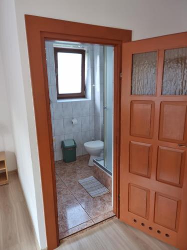 a bathroom with a door leading to a toilet at Pokoje Poniatowka in Nałęczów