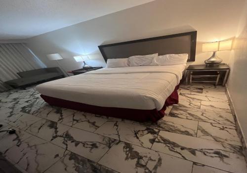 a bedroom with a large bed with a marble floor at Boutique Hotel in Texarkana