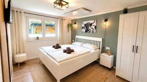 a bedroom with a large white bed and a window at Ferienhaus Seeoase - 70qm - Kamin -Terrassen - Parkplatz - Badestelle fußläufig in Joachimsthal