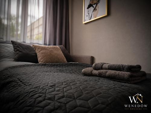 a bedroom with a bed with a blanket and a window at 104 Wenedów Noclegi in Koszalin