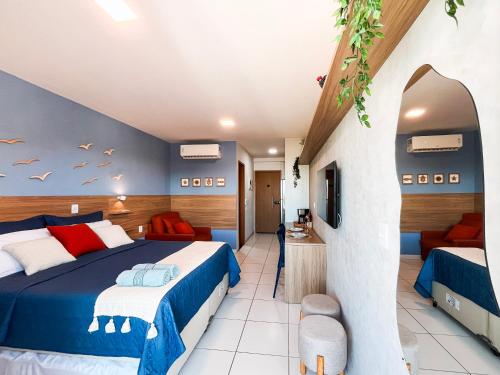 a bedroom with two beds and a living room at Malia Beach - Muro Alto - Porto de Galinhas - Cozinha equipada in Porto De Galinhas