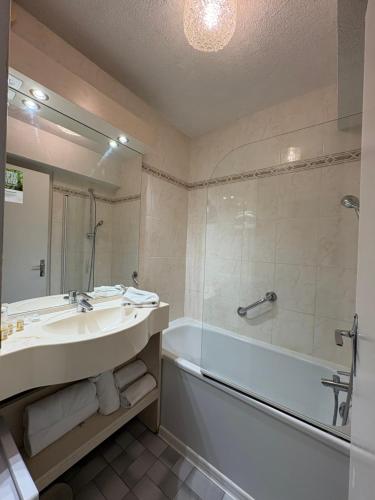 a bathroom with a sink and a tub and a shower at Hôtel La Redoute in Les Rousses