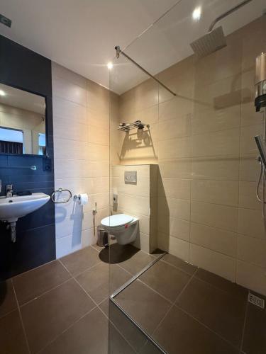 a bathroom with a toilet and a sink at Hotel SKØL in Strassen