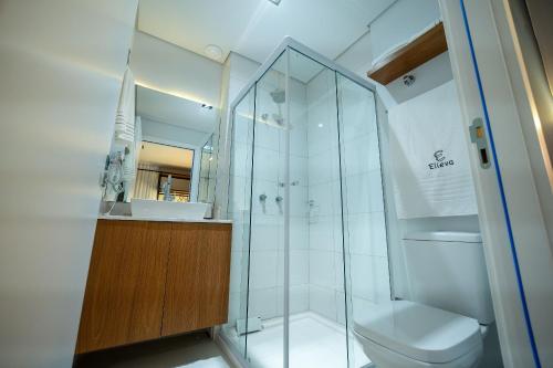 a bathroom with a shower and a toilet and a sink at ELLEVA STUDIOS | Studio moderno com coworking e rooftop em Sinop in Sinop