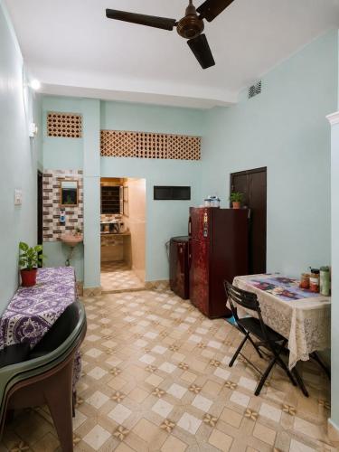 a kitchen with a table and a ceiling fan at Jagdamba Bhawan in Kolkata