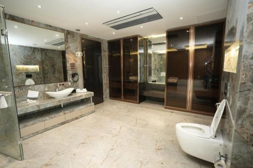 a bathroom with two sinks and a shower and a toilet at Estrella The Resort in Karjat