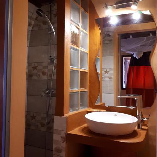 a bathroom with a white sink and a shower at hotel trecicogne in Morondava