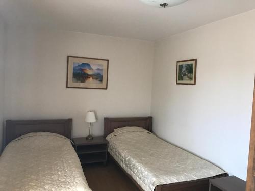 two beds in a room with white walls at Pilaites svetingi namai in Vilnius