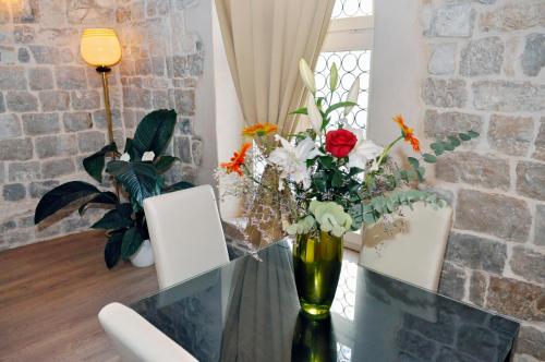 a vase of flowers sitting on a glass table at Grisogono Palace Heritage Residence in Split