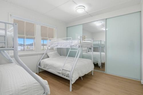 a bedroom with two bunk beds and a mirror at Central Coast Waterfront 2BR with Jetty Access in Koolewong