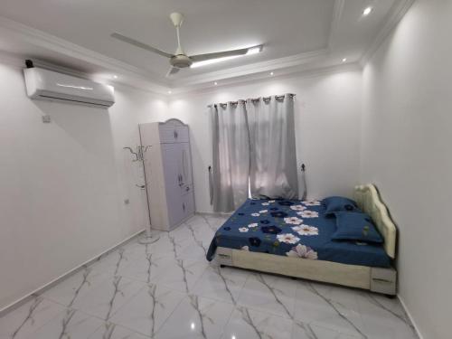 a bedroom with a bed in a white room at شاليه شاطئ خلوف in Khalūf