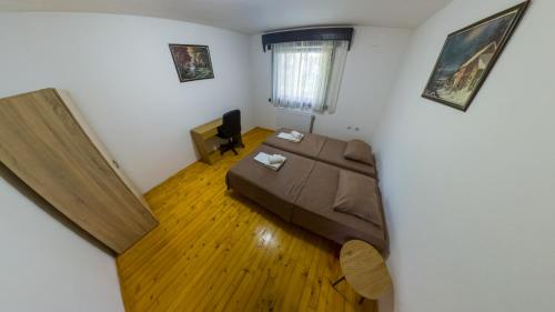 a small bedroom with a bed and a television at Gorska Vila Sisevac in Sisevac