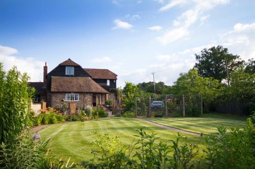 a house with a large lawn in front of it at Magpies Lodge in Slinfold
