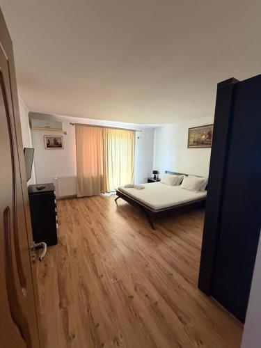a bedroom with a large bed and a wooden floor at Casa Doros in Eforie Sud