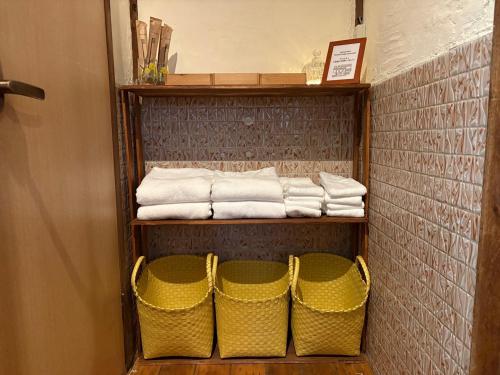 two baskets on a shelf in a bathroom with towels at Haraya in Nakatsugawa
