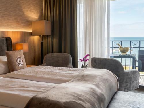 a hotel room with a large bed and a large window at Bayside in Scharbeutz