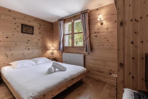 a bedroom with wooden walls and a large bed at Petit Bois - by Care Concierge in Demi-Quartier