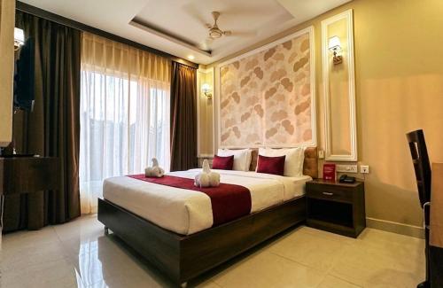 a hotel room with a bed with two stuffed animals on it at Odissey Suites in Bhubaneshwar