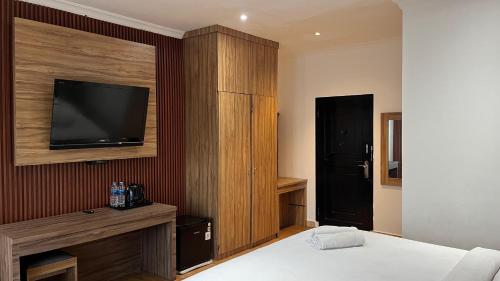 a bedroom with a bed and a tv on a wall at HOTEL MAJESTIC in Palembang