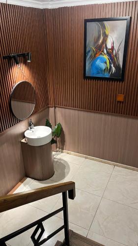 a bathroom with a sink and a painting on the wall at HOTEL MAJESTIC in Palembang
