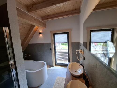a bathroom with a tub and a toilet and a sink at Schwarzwald Wellness Chalet in Todtnau