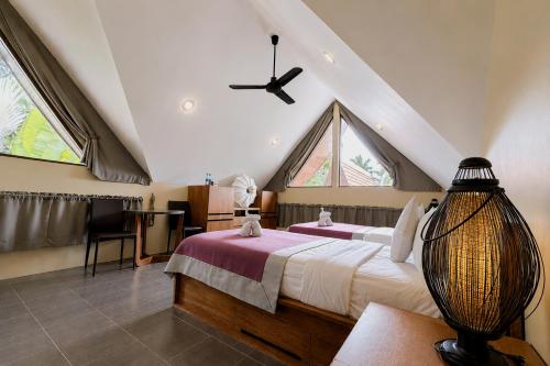 a bedroom with two beds and a ceiling fan at Tha Lane Bay Villas in Tha Lane Bay