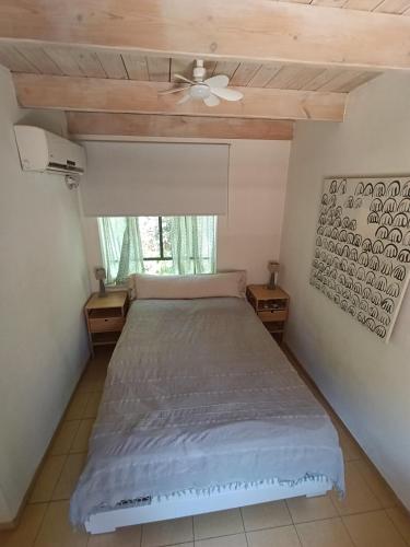 a bedroom with a bed and a ceiling fan at הקן לציפורים נודדות in Rosh Pinna