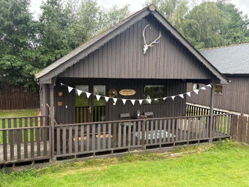 a black building with a clock on top of it at Braemar Lodge Cabins in Braemar