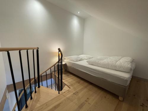 a small bedroom with a bed and a staircase at duplex confort Le pre marty in Albepierre-Bredons