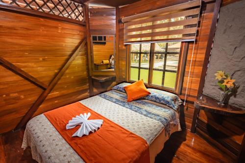 a bedroom with a bed in a room with a window at QUINTA PRIMAVERA - Hostería Campestre in Nueva Loja