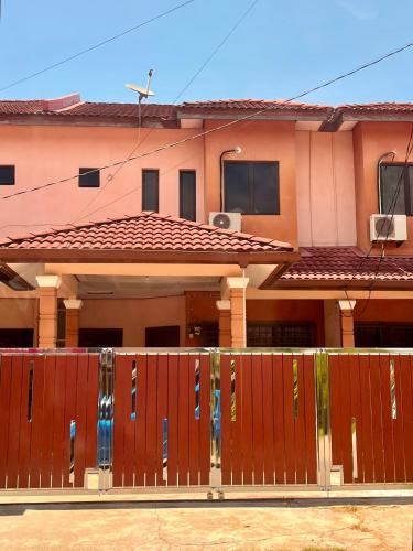 a house with a wooden fence in front of it at Chendering Beach Stay in Kuala Terengganu