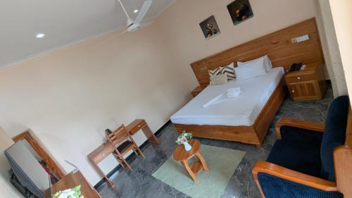a small bedroom with a bed and a chair at The Serene Maskani in Moshi