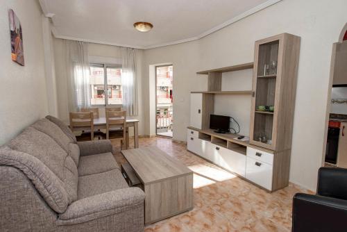 a living room with a couch and a table at Apartamentos Turísticos Fresno in Torrevieja