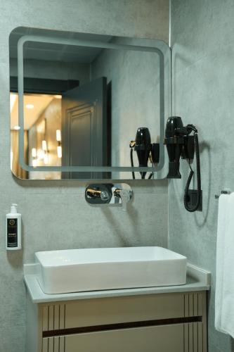 a bathroom with a white sink and a mirror at Midyat Bay Grand Hotel in Midyat
