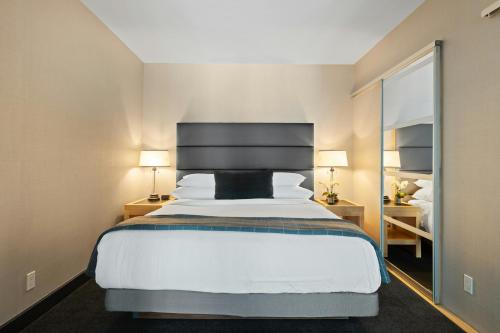 a bedroom with a large bed and a large mirror at Hotel Elanza Suites by Signature Stayz Near Delhi Airport in New Delhi