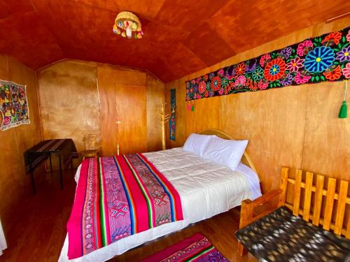 a bedroom with a bed and a bench in a room at Islas Chimu in Puno