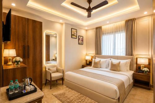 a bedroom with a large white bed and a chair at Hotel Grand Villa Suites Near Delhi International, IGI Airport in New Delhi