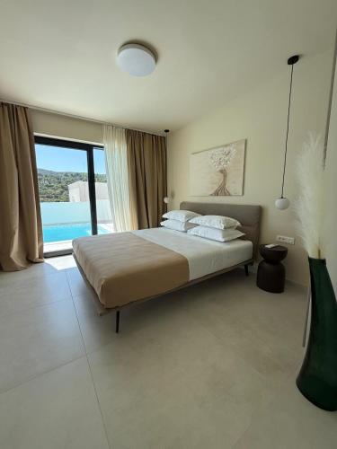 a bedroom with a bed and a large window at Villa Artemis III in Žman