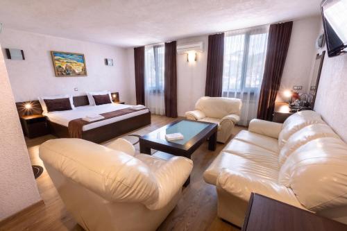 a living room with a couch and a bed and a room at Hotel Melnik Хотел Мелник in Melnik